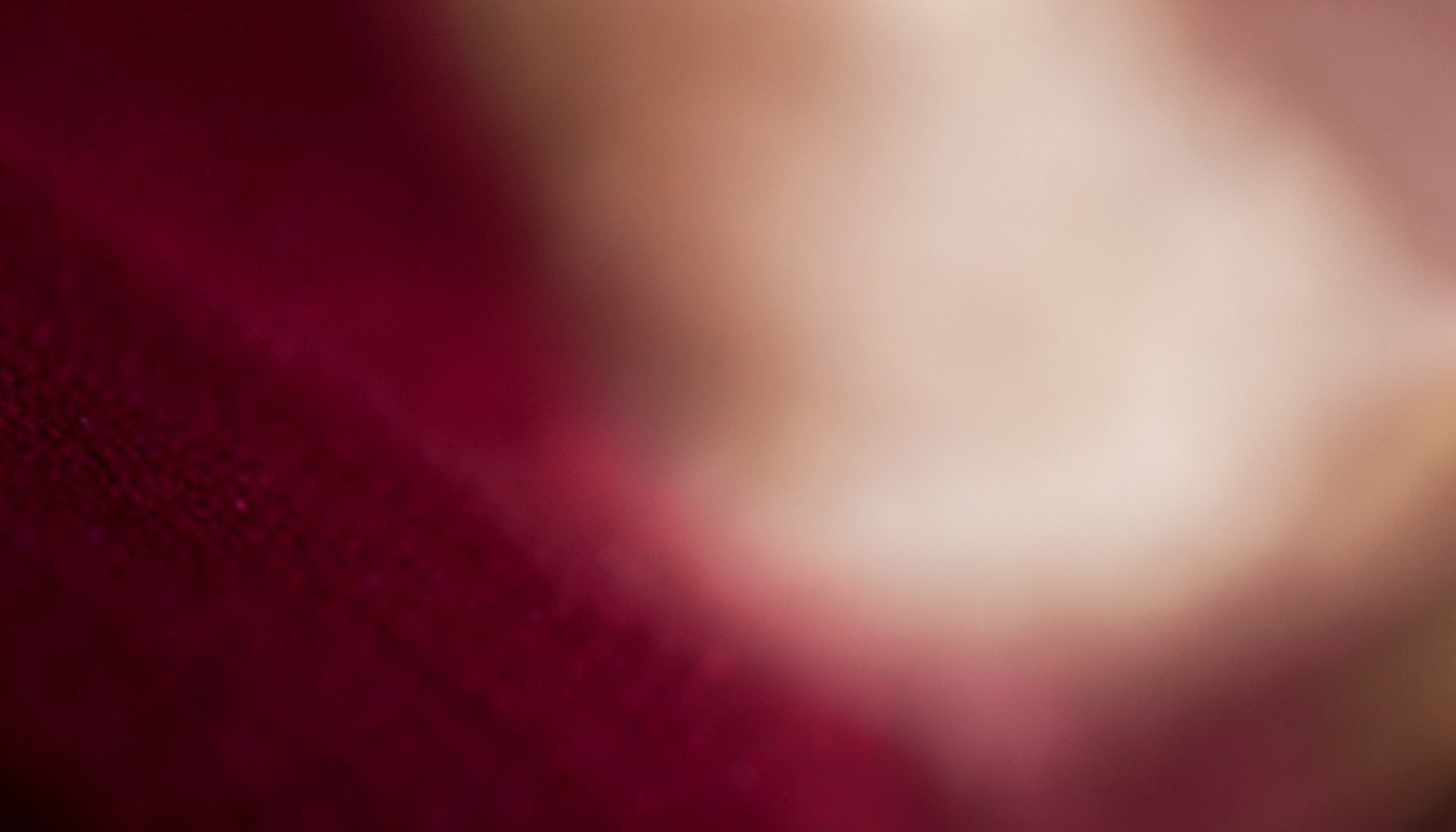 Soft, blurred gradient backdrop in deep maroon and warm cream, suggesting a calm professional atmosphere