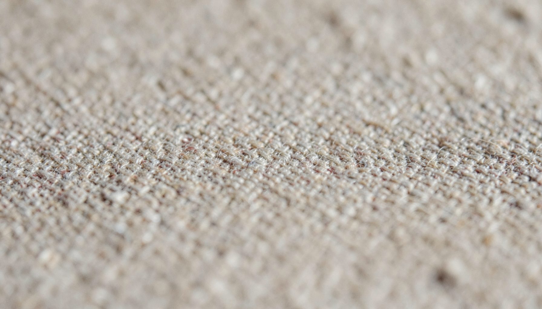 An abstract, textured surface in pale taupe and warm linen tones, calm and neutral in mood