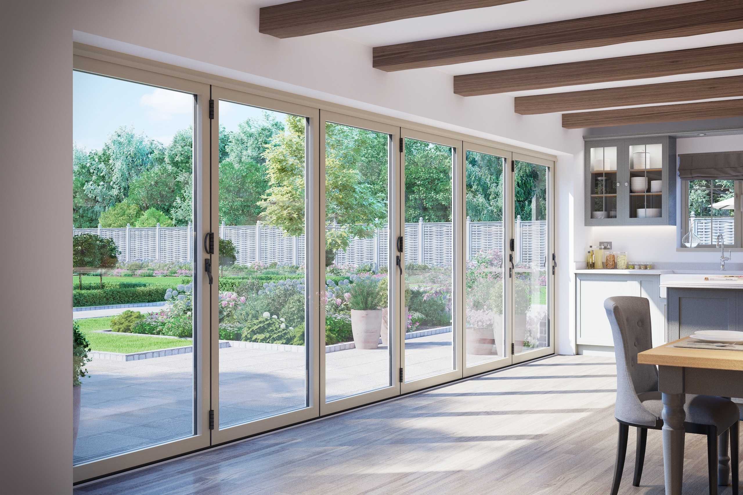 Interior view of a room with large multi-panel bifold glass doors opening onto a landscaped garden with lawn and flowers
