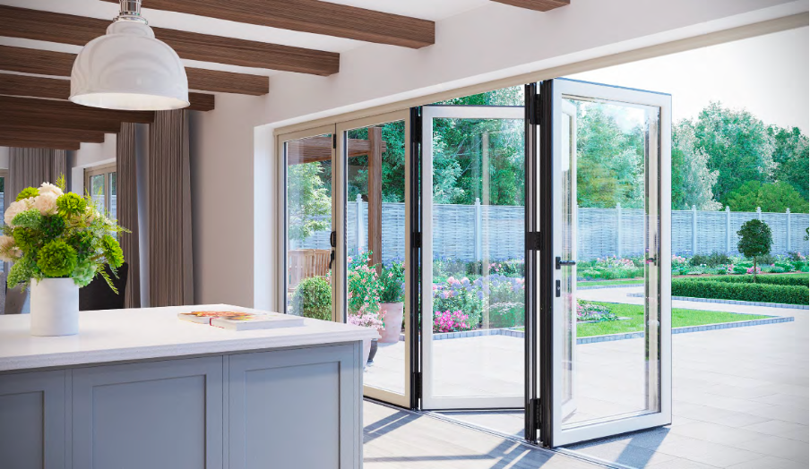 Interior kitchen view with a white countertop and flower arrangement in foreground, looking through open folding glass doors
